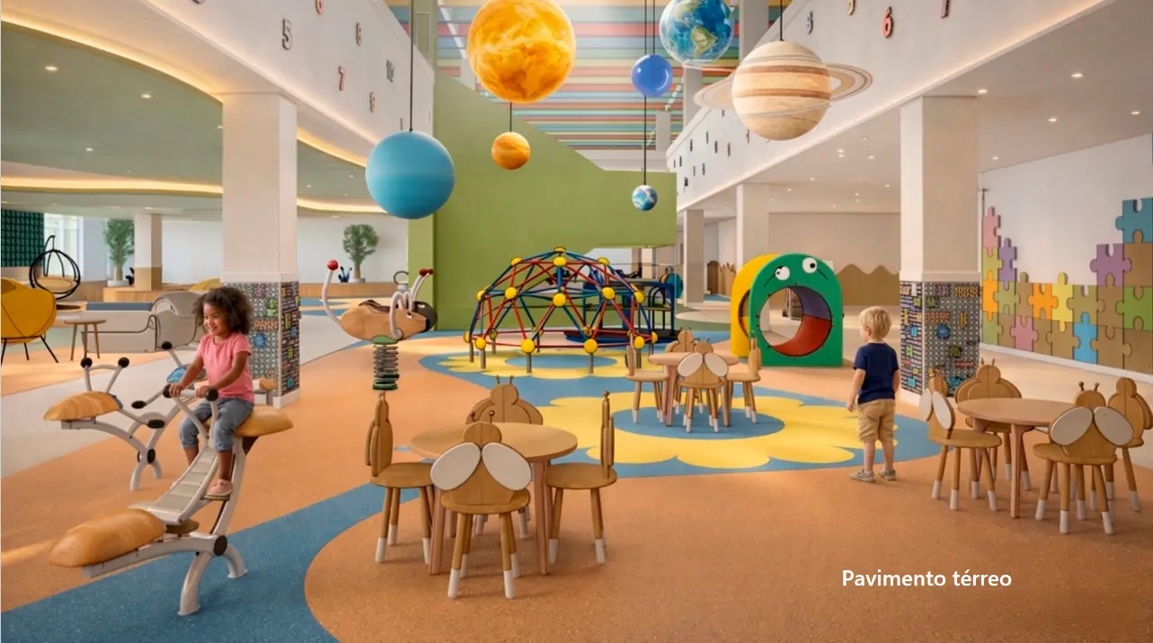 Espaço lúdico com mesas infantis, brinquedos e planetas suspensos no teto. Paredes decoradas com peças de quebra-cabeça e números. Uma menina brinca em um balanço e um menino observa o ambiente.